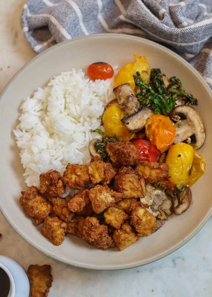 crispy air fried tofu in a bowl with rice and veggies.