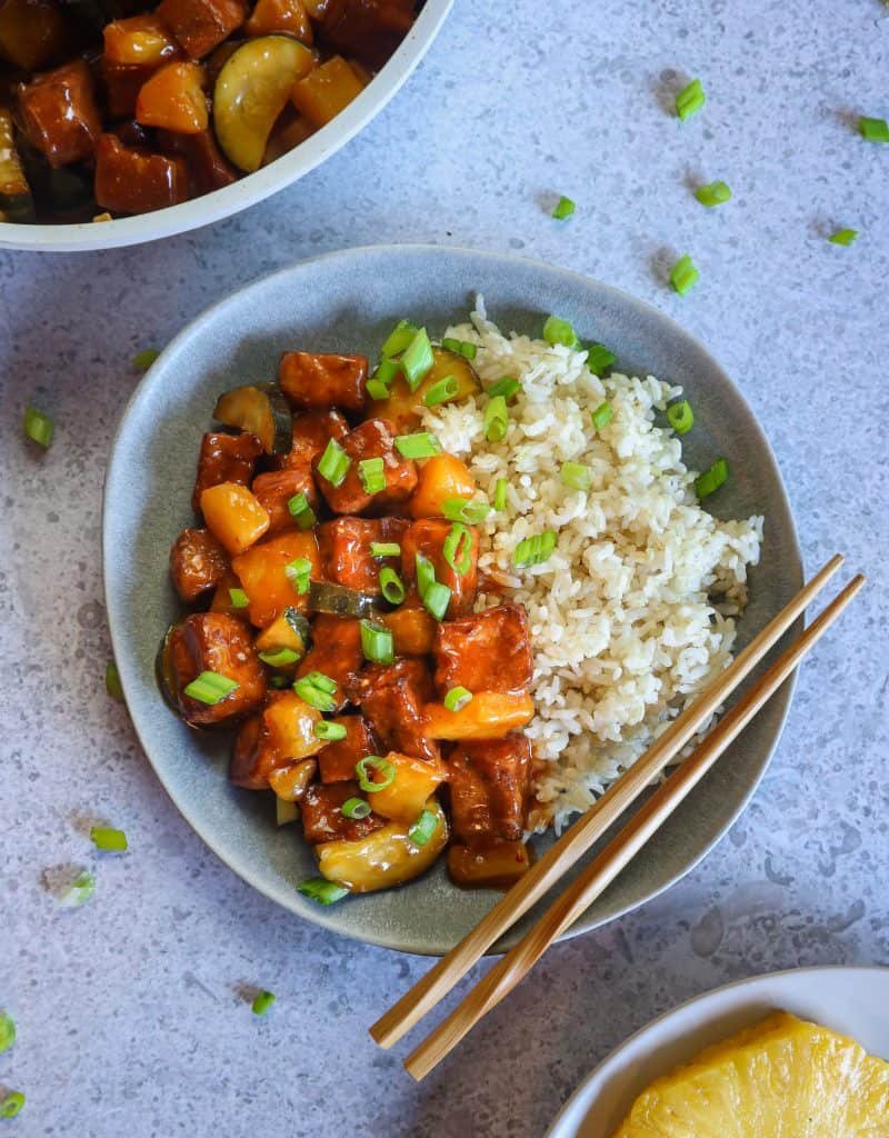 sweet and sour tofu on a plate with rice.