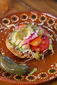 bean tostada on a mexican plate.