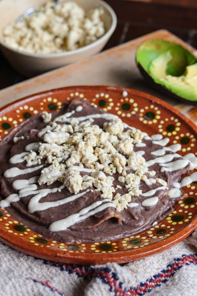 enfrijoladas on a mexican plate.