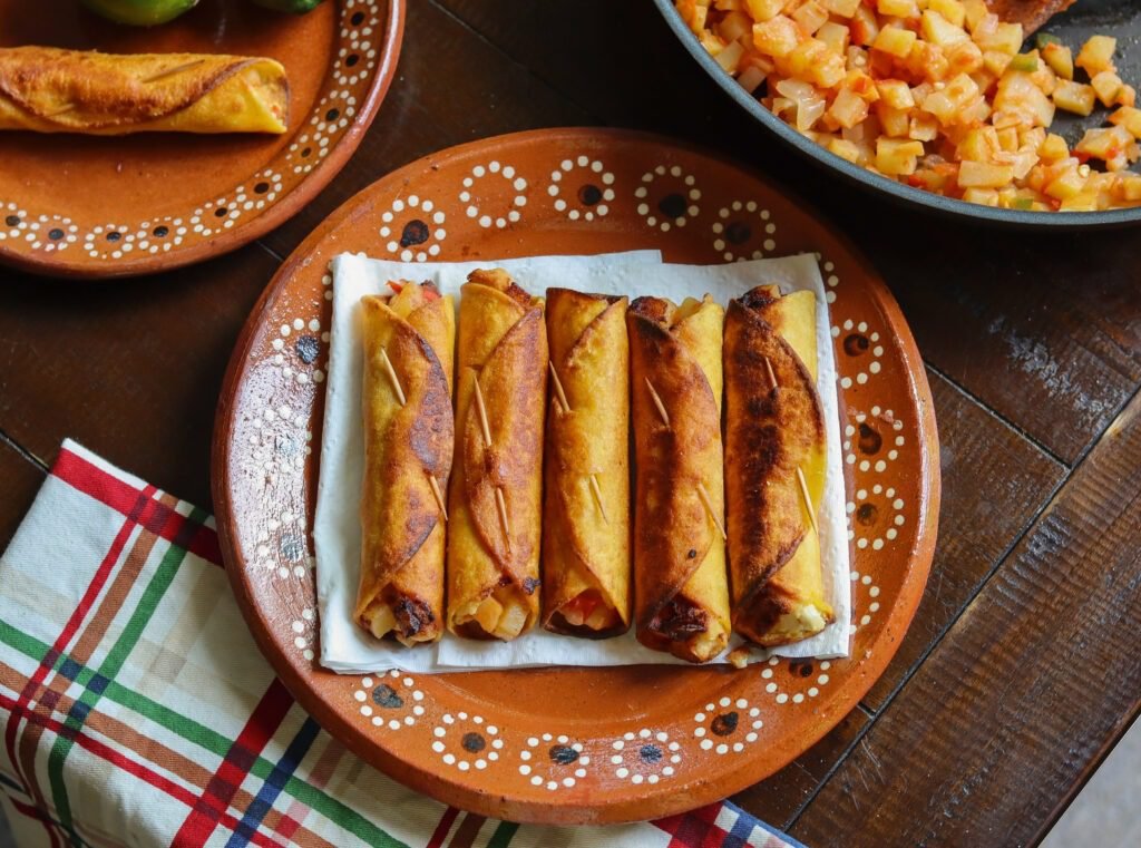 crispy golden potato flautas on a mexican dish.