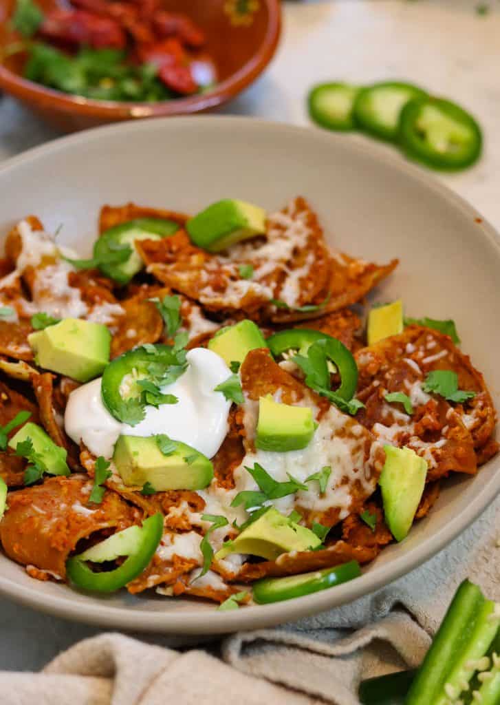 vegan chilaquiles on a plate with avocado.