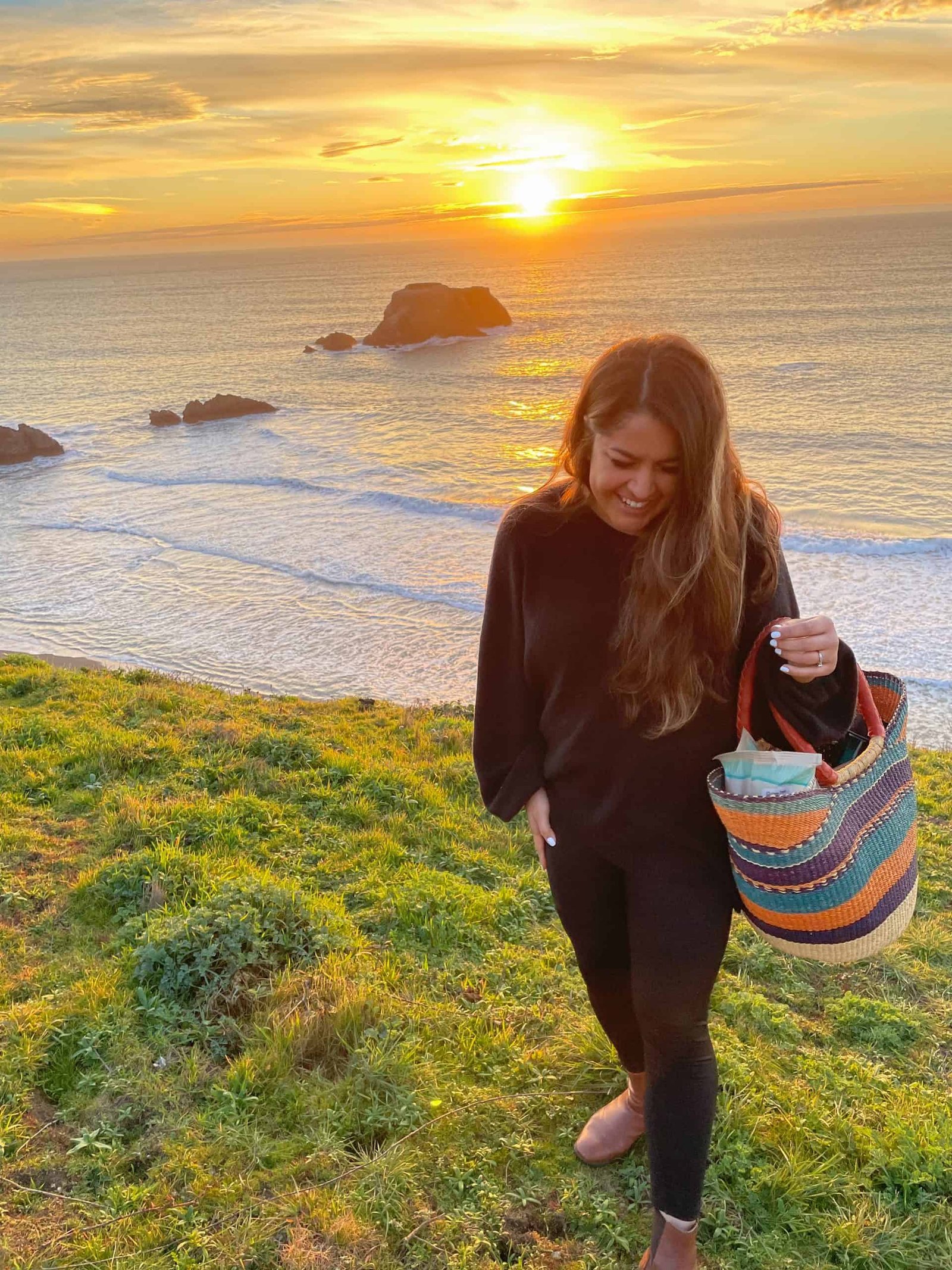 anna rios on the coast with a picnic bag.