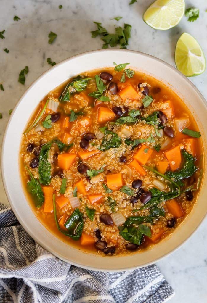 sweet potato quinoa soup in a bowl with lime and cilantro.