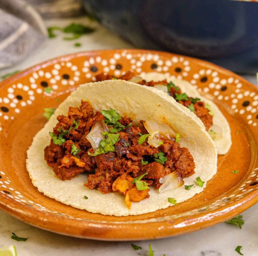 seitan al pastor tacos on a mexican plate.