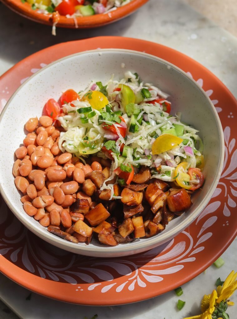 mexican cabbage slaw in a bowl with beans and meat.