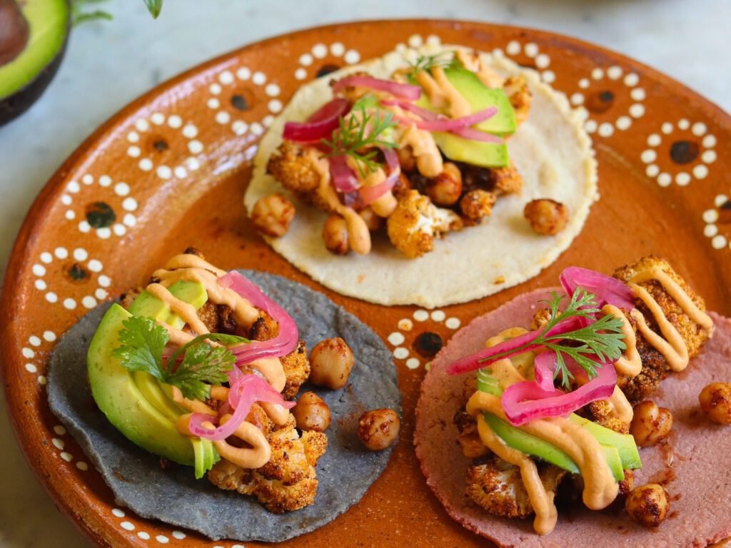 veggie cauliflower tacos made with homemade corn tortillas on a mexican plate.