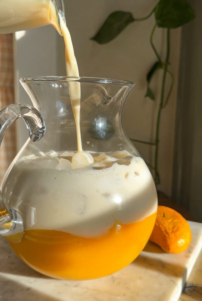 mango milk recipe in a glass pitcher.